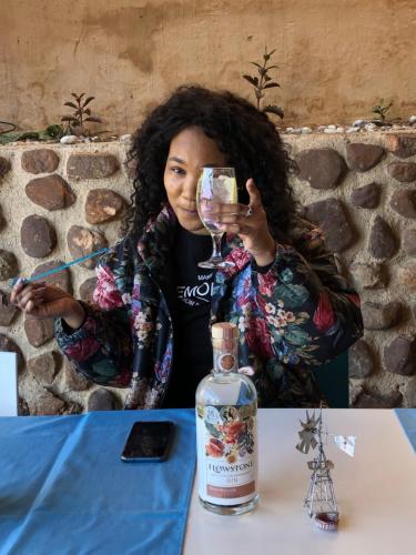 a woman sitting at a table with a glass of wine at Lanseria Country Estate in Lanseria