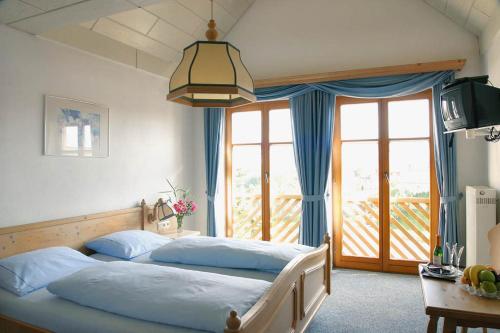 a bedroom with two beds and a large window at Landgasthof Bieg in Neuler