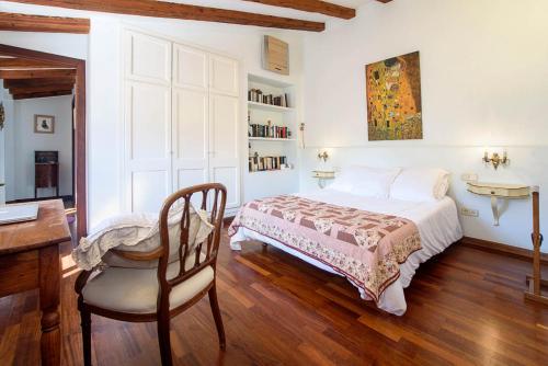 a bedroom with a bed and a desk and a chair at Ca’n Roega in Sóller