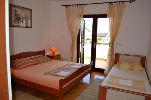 a bedroom with two beds and a sliding glass door at Apartments Karlo in Omiš