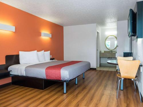 a hotel room with a bed and a table and chairs at Motel 6-Columbus, OH - OSU in Columbus