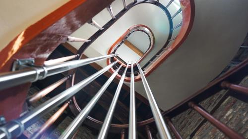 a spiral staircase in a building with a window at Amosa Liège City Centre Hotel in Liège