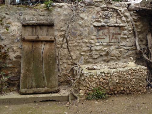 an old stone building with a wooden door and windows at Casa Rural Torre De Campos in Ainzón