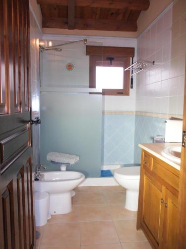 a bathroom with two toilets and a sink and a shower at LA CASA DE LAS AZAS in Casla