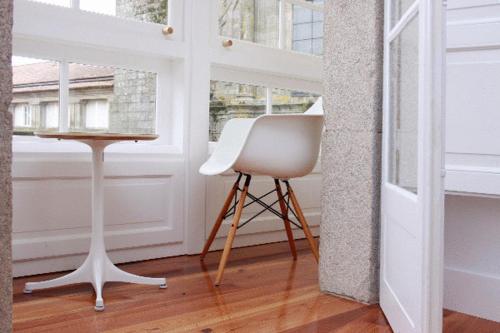 a white chair in a room with a window at Hotel Pazo de Altamira in Santiago de Compostela