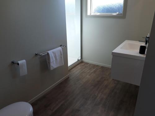 a bathroom with a white sink and a toilet at South City Accommodation Unit 1 in Invercargill