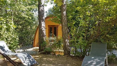 a small yellow house in the middle of trees at Camping-Hotel de Plein Air Les 2 Bois in Baratier