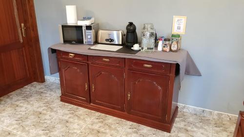 a kitchen with a counter with a coffee maker and a microwave at The Emigrant House in Biscoitos