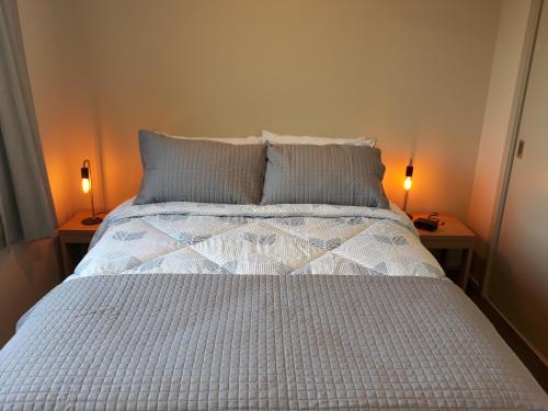 ein Schlafzimmer mit einem Bett mit zwei Lampen an zwei Tischen in der Unterkunft South City Accommodation unit 3 in Invercargill