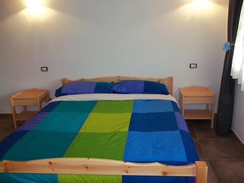 a bedroom with a colorful bed with two tables at Agriturismo Rio Castello in Marina dʼAndora