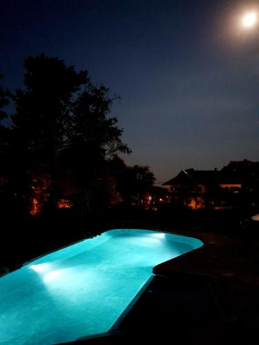 a blue swimming pool at night with the moon at Hotel La Cumbrecita in La Cumbrecita