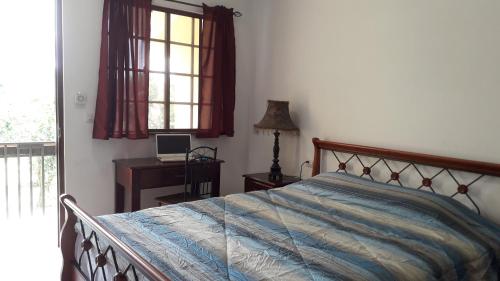 een slaapkamer met een bed, een bureau en een raam bij Aparthotel Boquete Apartments in Boquete