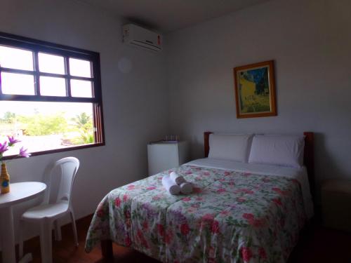 um quarto com uma cama com um bicho de peluche em Kazaya Pousada em Araruama