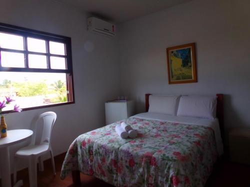 a bedroom with a bed with a stuffed animal on it at Kazaya Pousada in Araruama