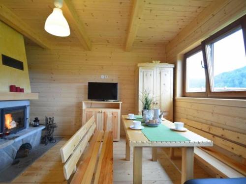 a wooden room with a table and a fireplace at Domki Czterech Braci in Grywałd