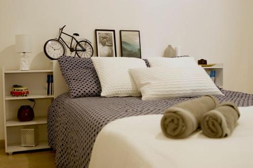 - une chambre avec un lit avec des oreillers et une horloge dans l'établissement Appart Faubourg St Pierre, à Nancy