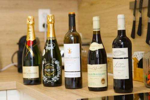 quatre bouteilles de vin assises sur une étagère dans l'établissement Appart Faubourg St Pierre, à Nancy