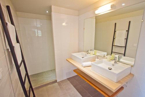 La salle de bains est pourvue de 2 lavabos et d'un miroir. dans l'établissement O Coeur de Deshaies Appartements Grande Anse et Amandiers, à Deshaies