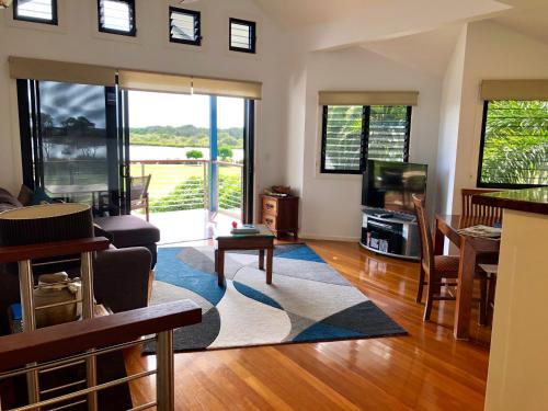 a living room with a couch and a tv at The Boathouse in Yamba