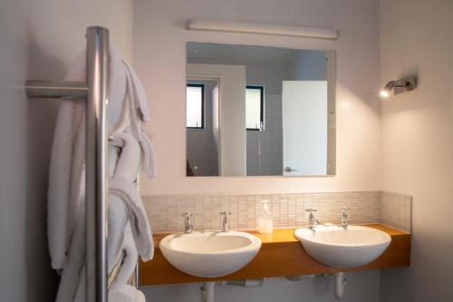 a bathroom with two sinks and a large mirror at Rataview in Barrytown