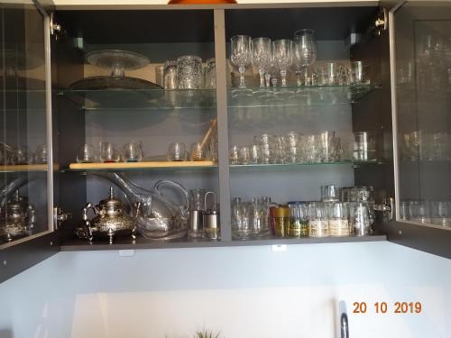 une armoire remplie de verres et d'autres objets en verre dans l'établissement Victoria Family House Disneyland Paris, à Serris