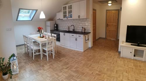 eine Küche und ein Esszimmer mit einem Tisch und einem TV in der Unterkunft Lavender Hill in Messinghausen