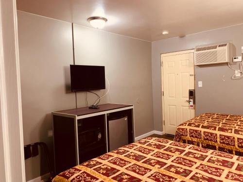 a hotel room with two beds and a flat screen tv at Red Carpet Inn - Norristown in Norristown