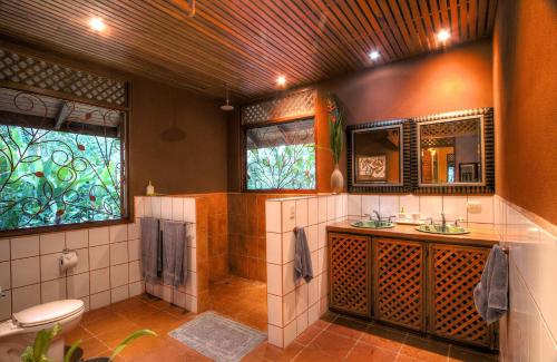 a bathroom with a shower and a toilet and a sink at Geckoes Lodge in Cocles