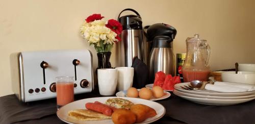 a table topped with plates of food and drinks at Aivlys Lodge Kilimanjaro in Msaranga