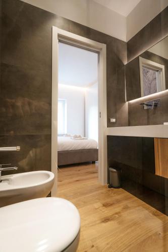 a bathroom with a toilet and a sink and a bed at NIMA Boutique House in Perugia