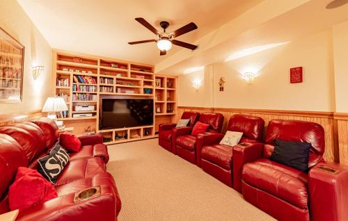 a living room with red leather couches and a flat screen tv at Sea Shellter in Whalebone