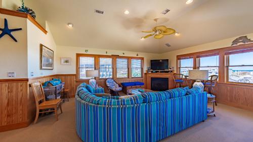 a living room with a large blue couch and chairs at Sea Shellter in Whalebone