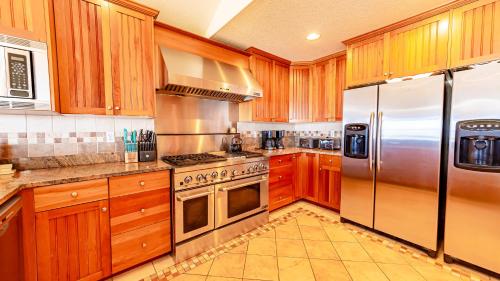 a kitchen with wooden cabinets and stainless steel appliances at Sea Shellter in Whalebone