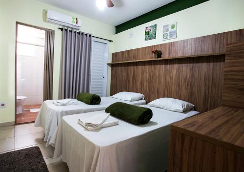 um quarto de hotel com duas camas com toalhas verdes em Hospedaria Lumo Domo Praça da Árvore em São Paulo
