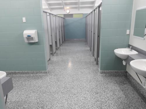 La salle de bains est pourvue de 2 lavabos et de 2 toilettes. dans l'établissement Opunake Beach Kiwi Holiday Park, à Opunake