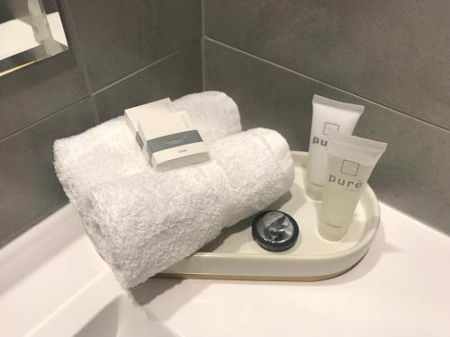 a white bath tub with towels and a scale on a sink at Risdon Brook Hotel in Risdon