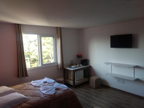 um quarto de hotel com uma cama e uma janela em Casa Zanata em Gramado