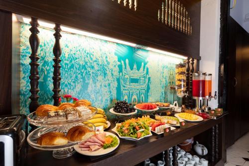 a buffet with many plates of food on a table at Hanoi Center Silk Lullaby Hotel and Travel in Hanoi