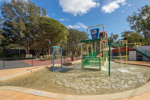 a park with a fountain and a roller coaster at Ingenia Holidays Bonny Hills in Bonny Hills