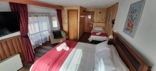 a hotel room with two beds and a flat screen tv at Hostal Vista al Mar hct in Ancud