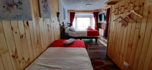 a small room with two beds and a window at Hostal Vista al Mar hct in Ancud