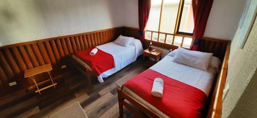 a bedroom with two beds and a window at Hostal Vista al Mar hct in Ancud
