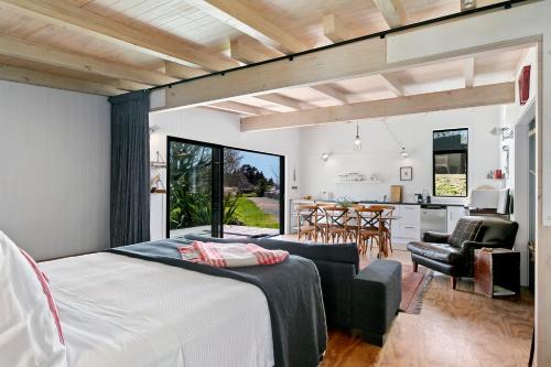 a bedroom with a bed and a living room and a kitchen at Hare's Rest in Taupo