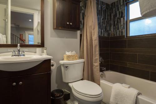 a bathroom with a toilet and a sink and a tub at 2br Empire Avenue WALK to Lifts and Main St - No Car Required! in Park City
