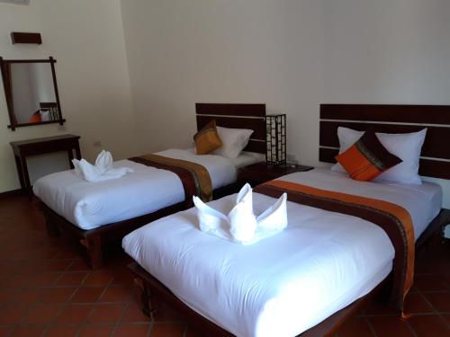 a group of three beds in a room at Villa Chitchareune 2 in Luang Prabang