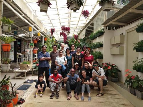 a group of people posing for a picture in a greenhouse at Moonriver Lodge in Cameron Highlands