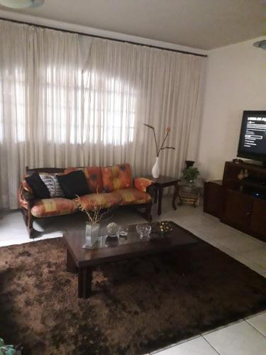 a living room with a couch and a coffee table at Hospedagem domiciliar in Guarujá