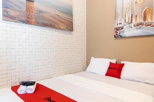 una camera con un letto con una coperta rossa e bianca di RedDoorz near Alun Alun Kudus 2 a Kudus