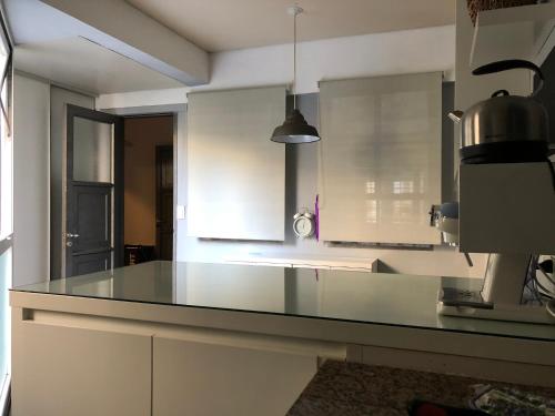 cocina con encimera de cristal en una habitación en Stylish and spacious city center apartment en Rosario