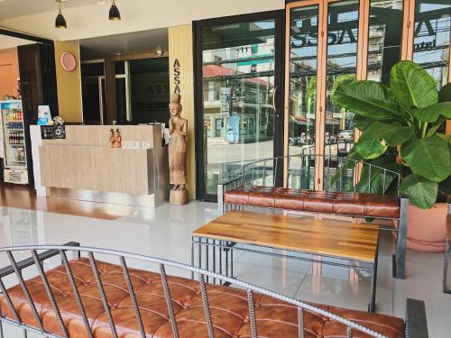 a lobby with two benches and a statue in front of a store at Assasa Huahin in Hua Hin